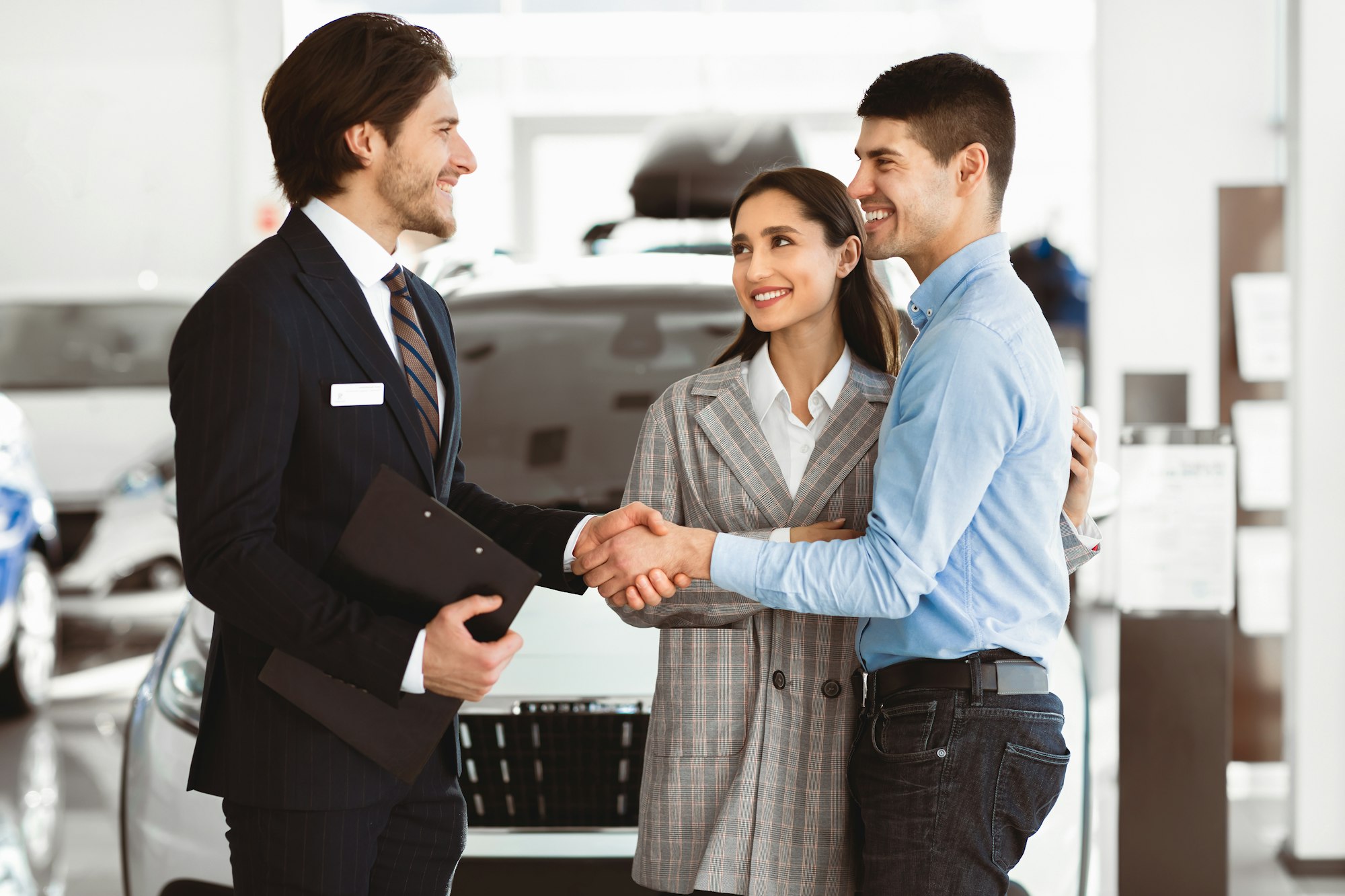 Man Shaking Hands With Car Sales Manager In Dealership Store
