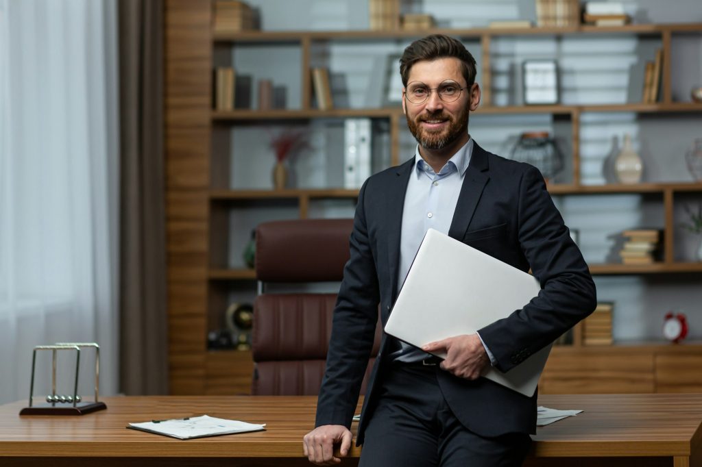 Portrait of successful and happy mature university teacher, man in business suit and academy